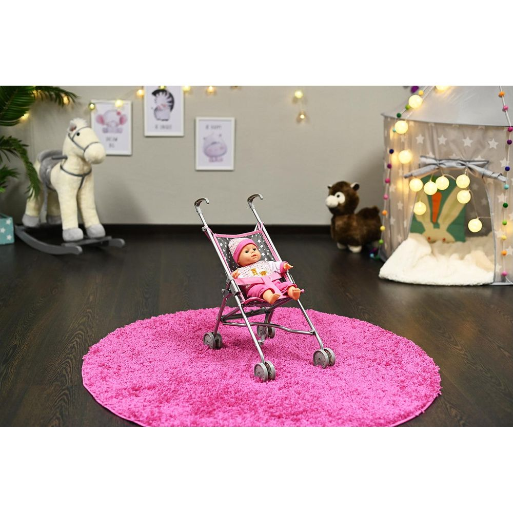 Puppe im Kinderwagen auf rosa Teppich, Spielzeugpferd und Zelt im Hintergrund.