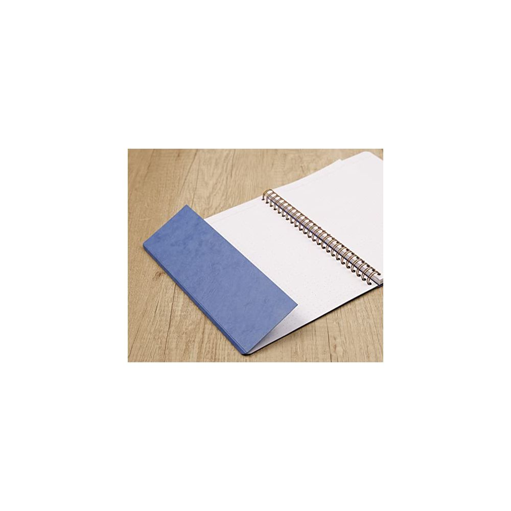Ein blaues Lesezeichen liegt auf einem aufgeschlagenen Notizbuch.