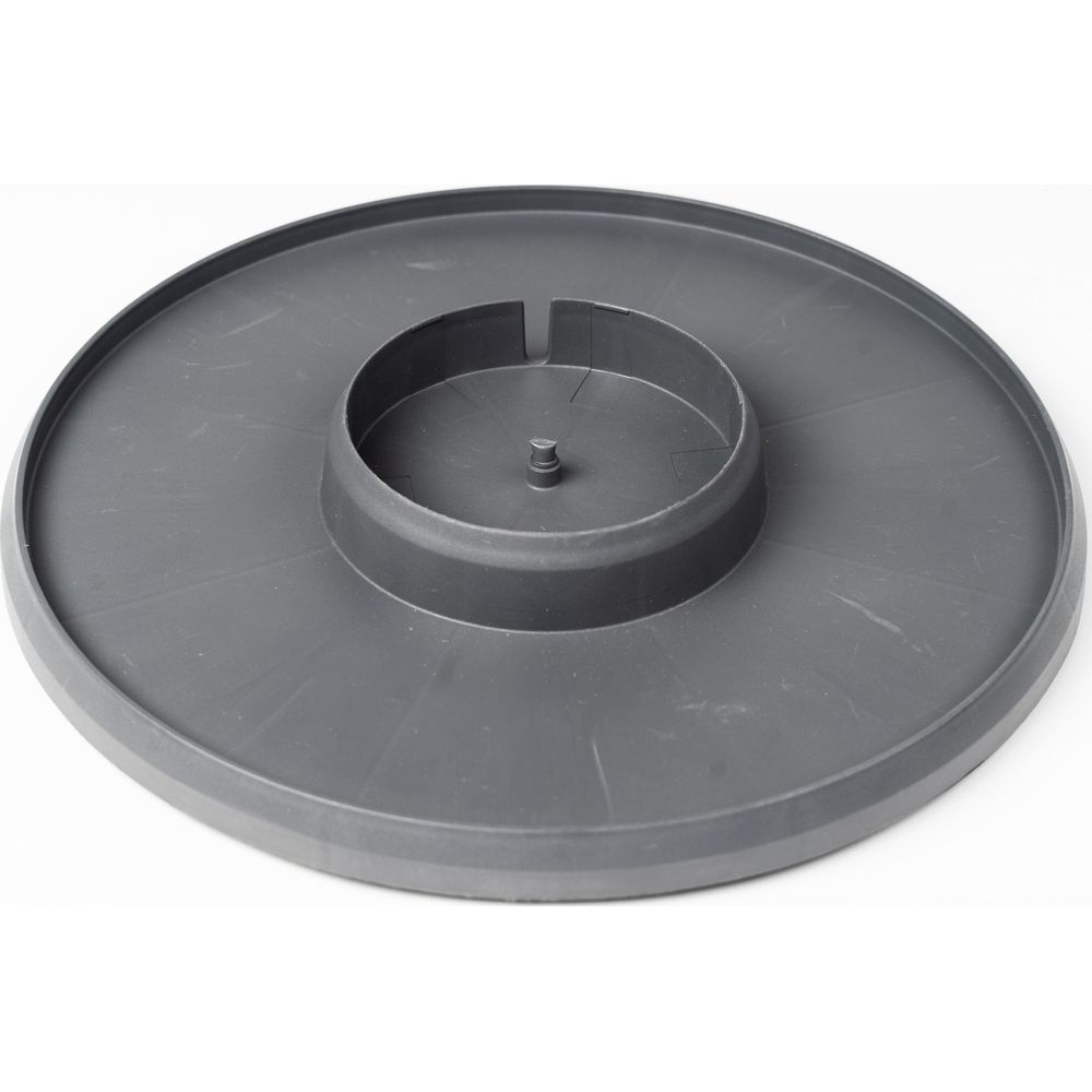Un plateau circulaire en plastique gris avec un anneau intérieur surélevé et un poteau central.