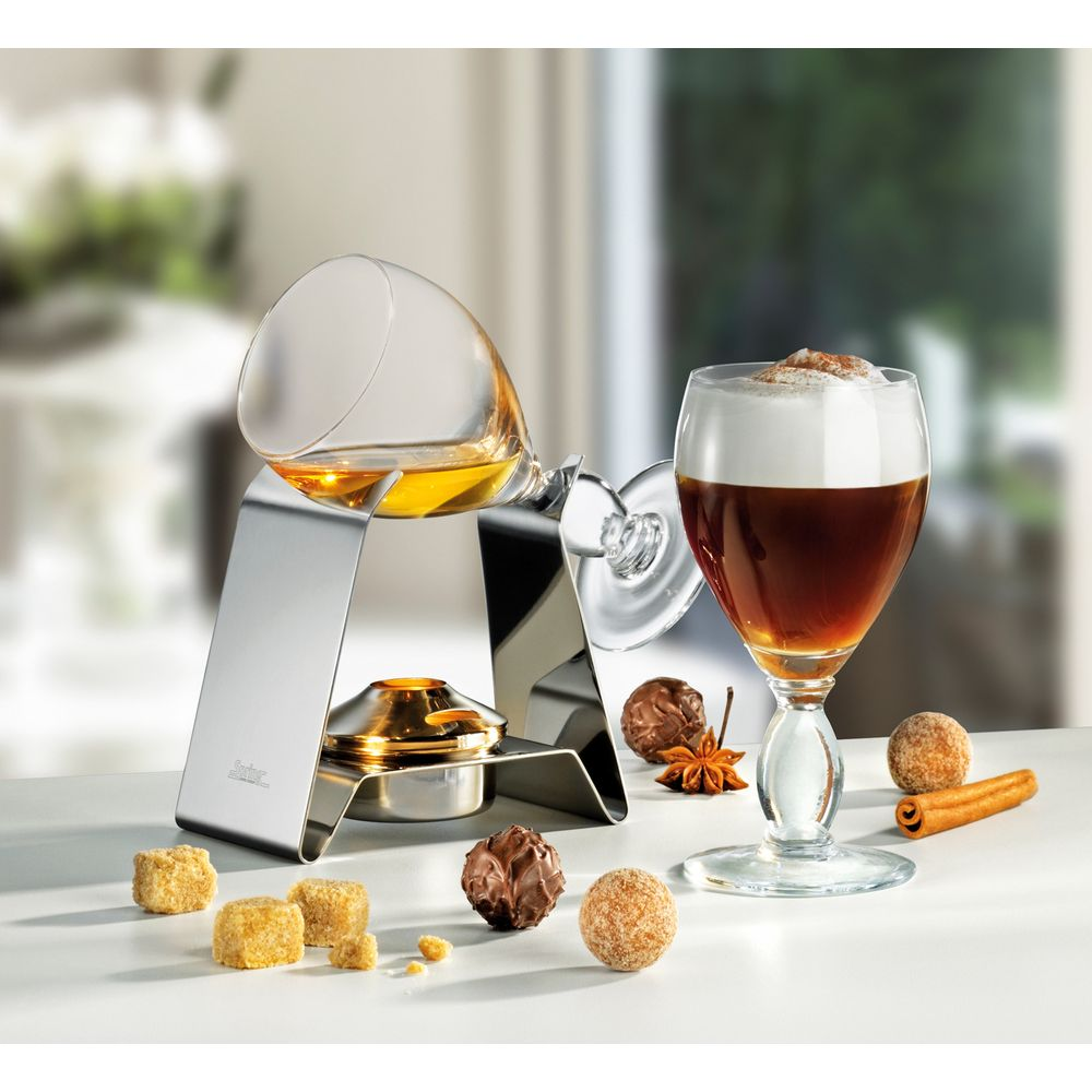 Ein Glas mit braunem Getränk und Sahne, daneben ein Schnapsgläschen mit Schnaps.