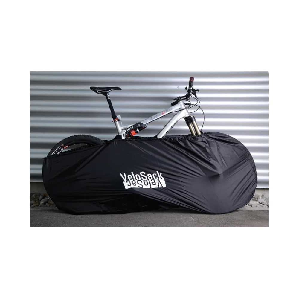 Un vélo argenté est recouvert d'un sac noir VeloSack.