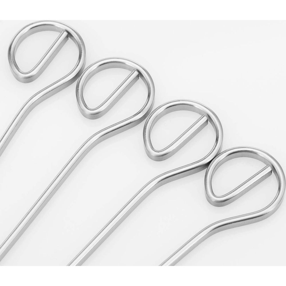 Quattro strumenti metallici argentati con manici rotondi giacciono uno accanto all'altro.