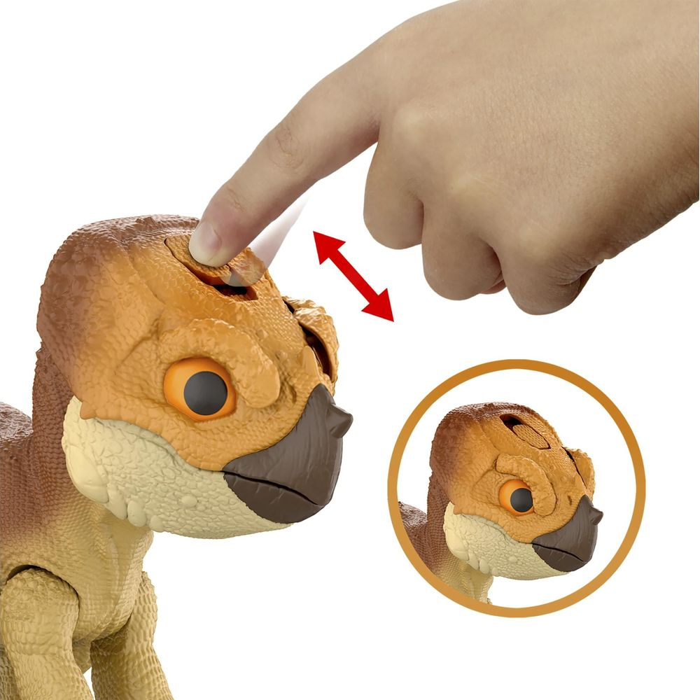 Ein Finger drückt auf den Kopf eines braunen Dino-Spielzeugs. Ein Kreis zeigt sein Gesicht.