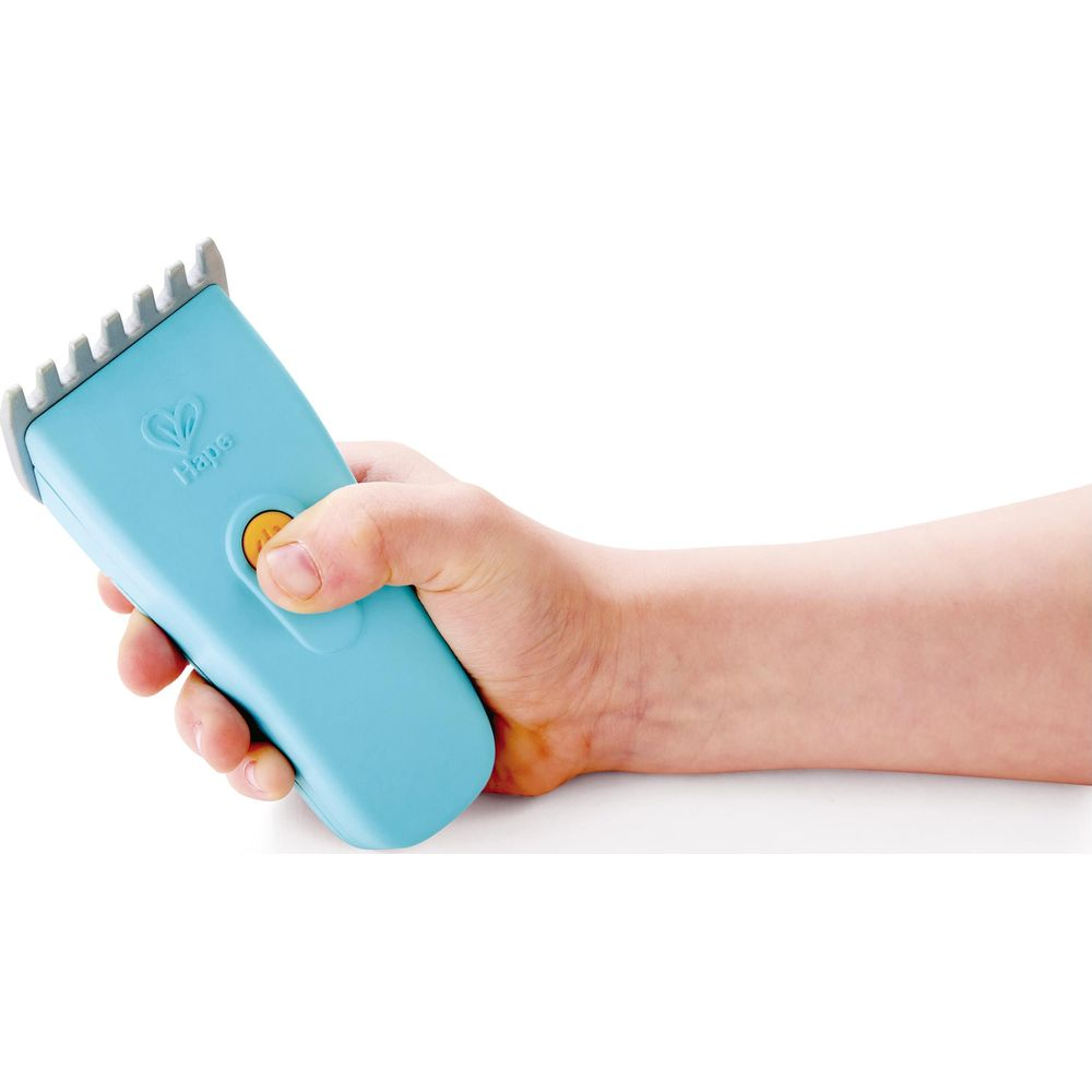 Eine Hand hält einen blauen Spielzeugrasierer mit einem gelben Knopf.