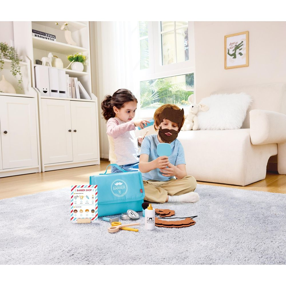 Ein Mädchen schneidet einem Jungen mit Bart und Spiegel die Haare.