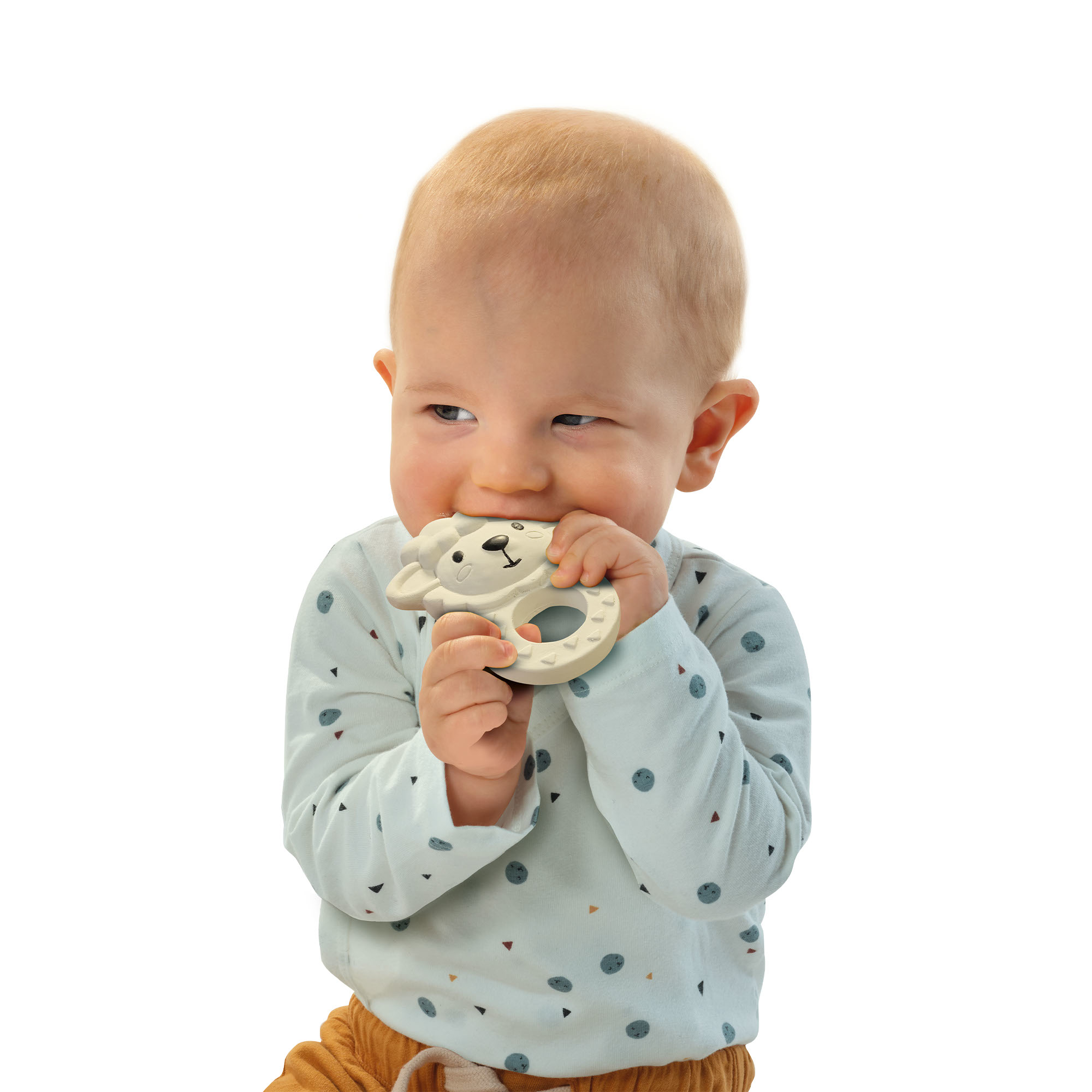 Ein Baby mit blonden Haaren kaut auf einem hellbeigen Beißring in Form eines Bären.