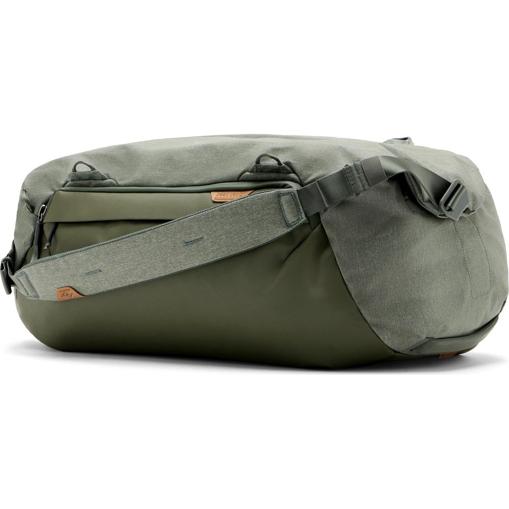 A green duffel bag with a strap across it. The bag has zippers and pockets.