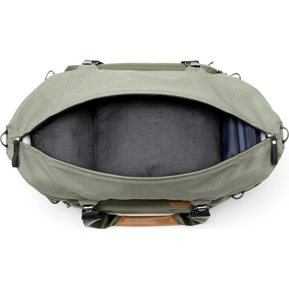 Green bag with open compartment and inserts. Brown leather handle on top.