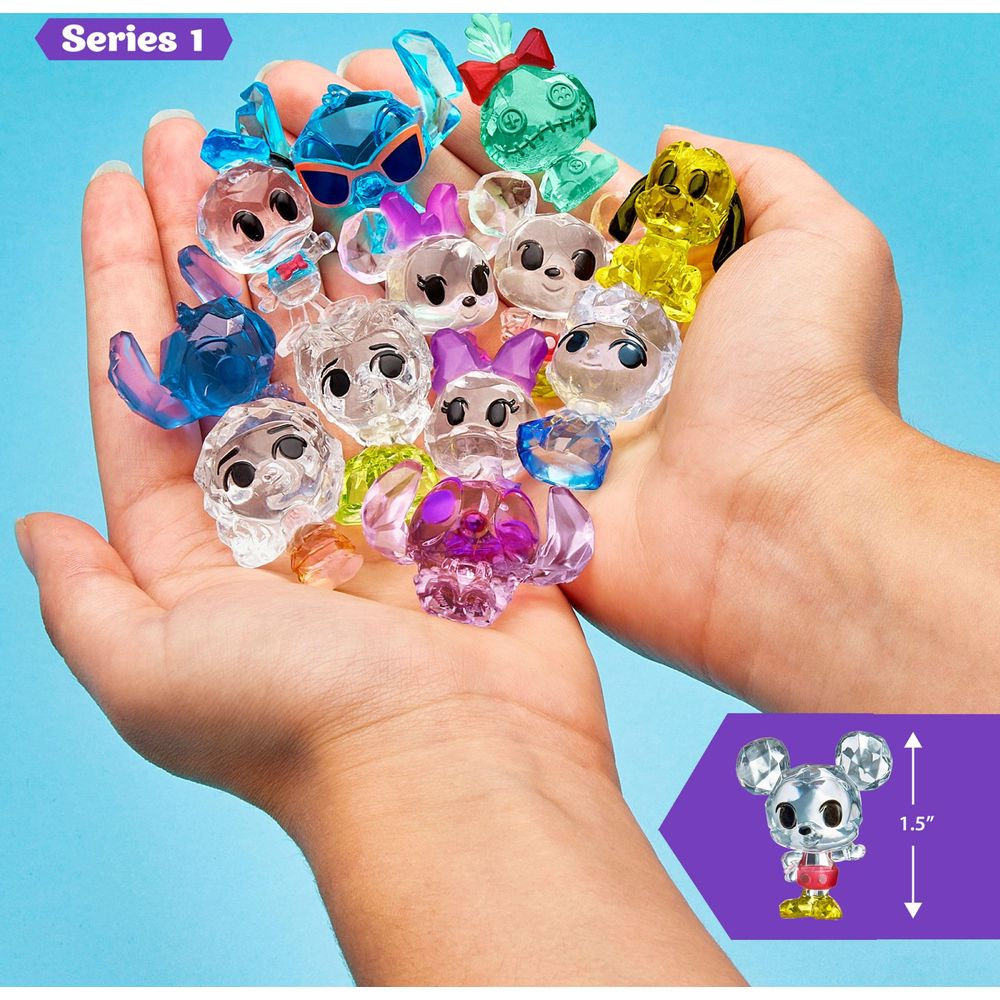 Mains tenant de nombreuses figurines colorées et translucides style Disney. Une figurine Mickey est montrée.