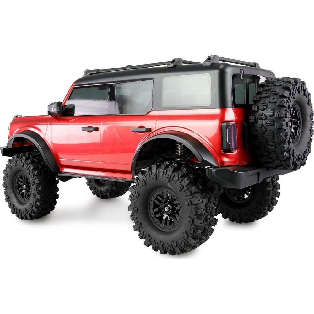 Ein rotes RC-SUV mit schwarzen Rädern und Ersatzrad auf der Rückseite.