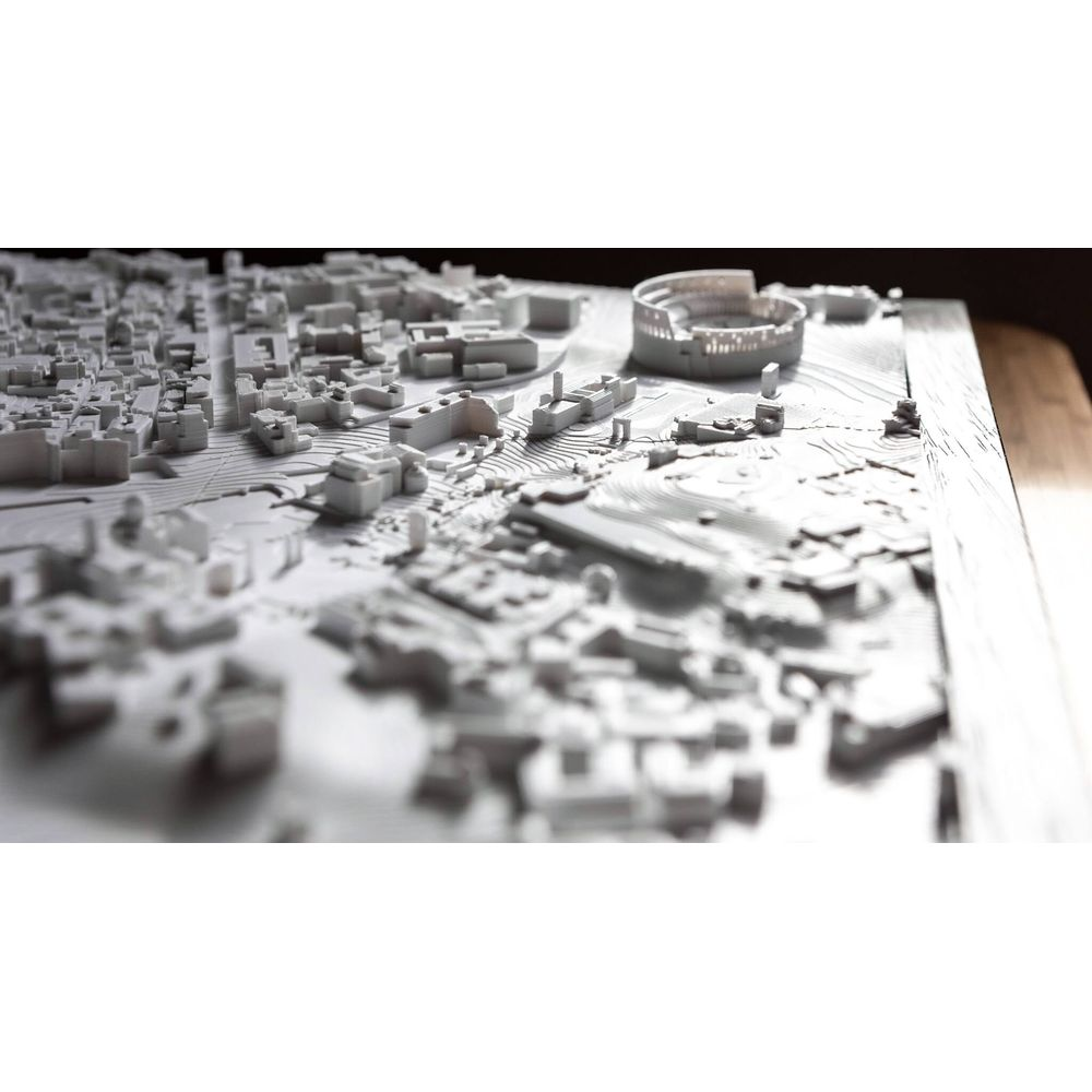 Une maquette architecturale blanche d'une ville montrant des bâtiments et des rues.