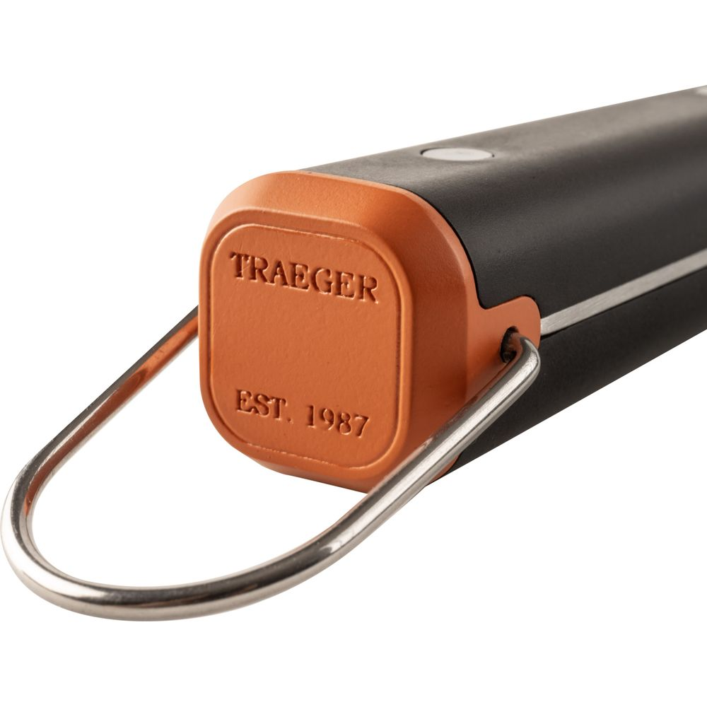 Un manico arancione con "TRAEGER EST. 1987" e un anello metallico.