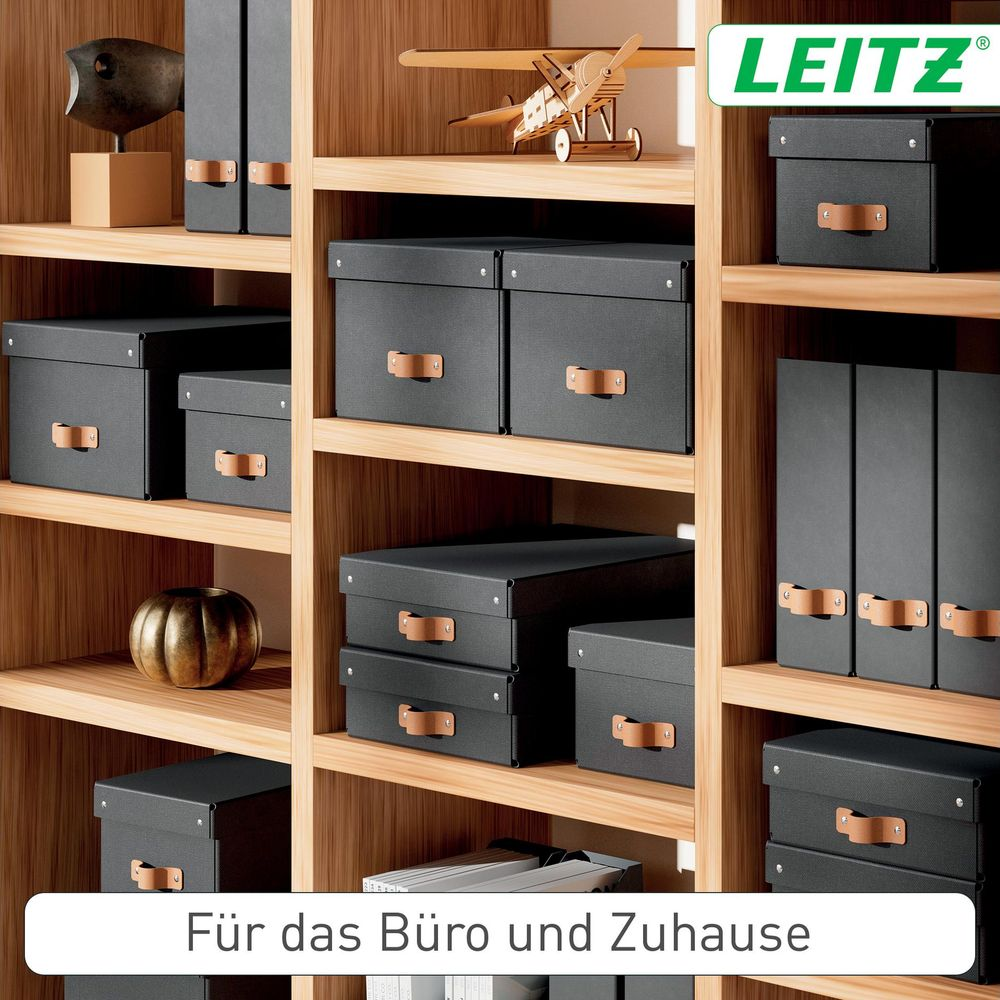 Schwarze Aufbewahrungsboxen und Ordner auf Holzregalen, Leitz Logo oben rechts.