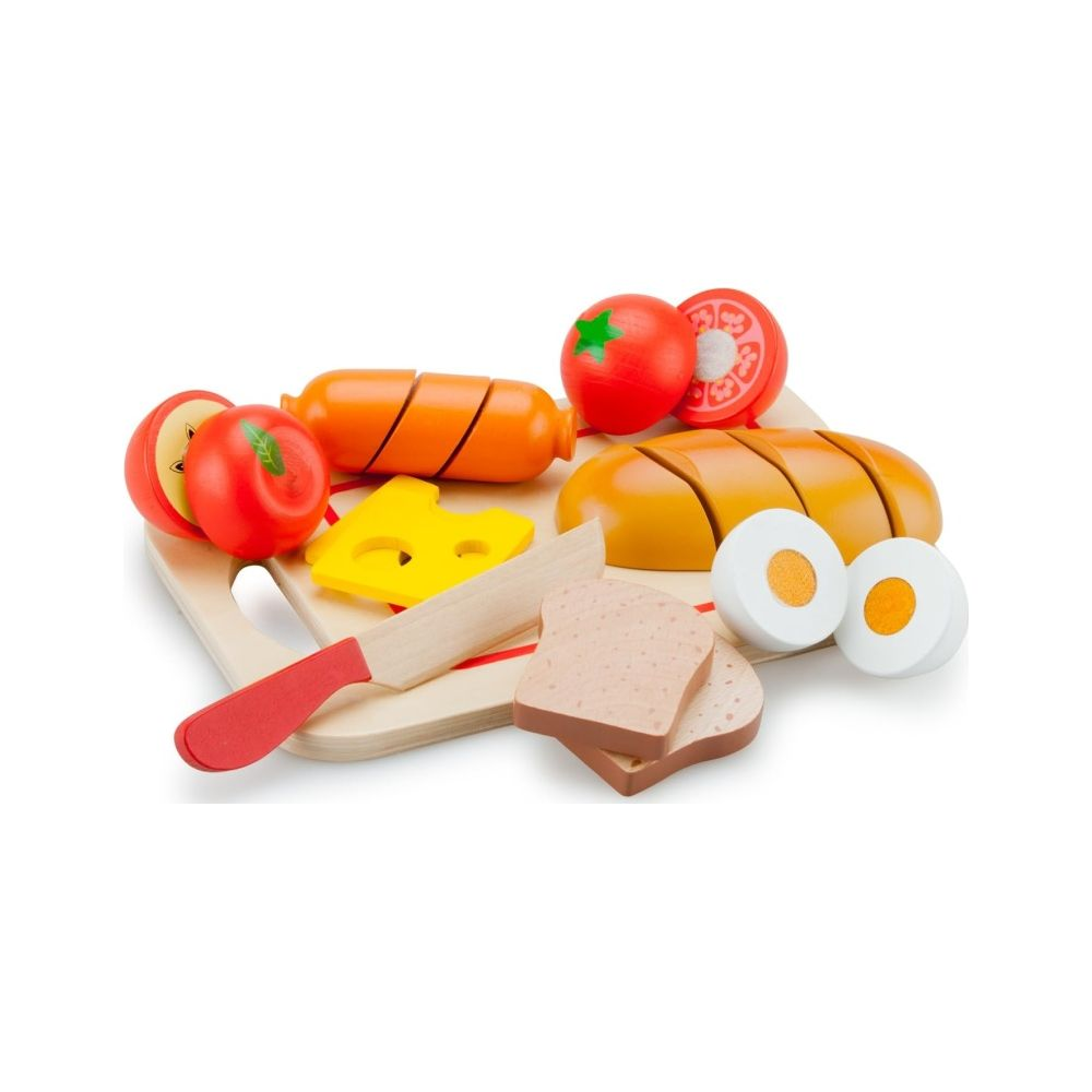 Cibo giocattolo su tagliere: pane, salsiccia, formaggio, pomodori, uova, mela, coltello.