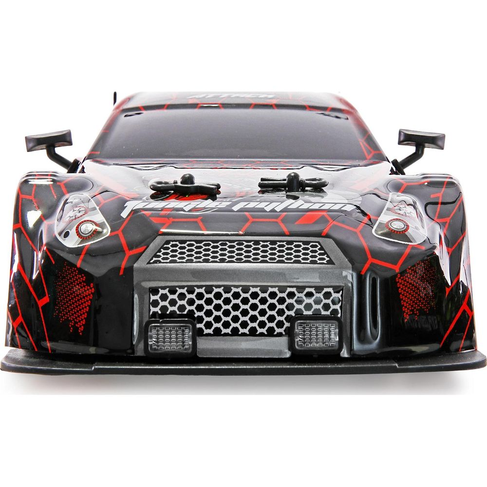 Vista frontal de un coche teledirigido negro con patrón hexagonal rojo. Rejilla blanca.