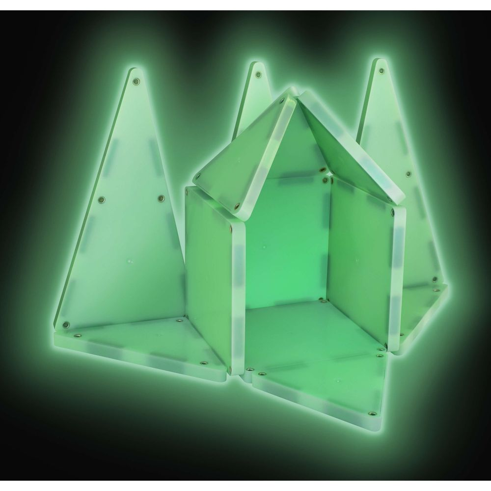 Blocs de construction verts phosphorescents forment une maison sur fond noir.