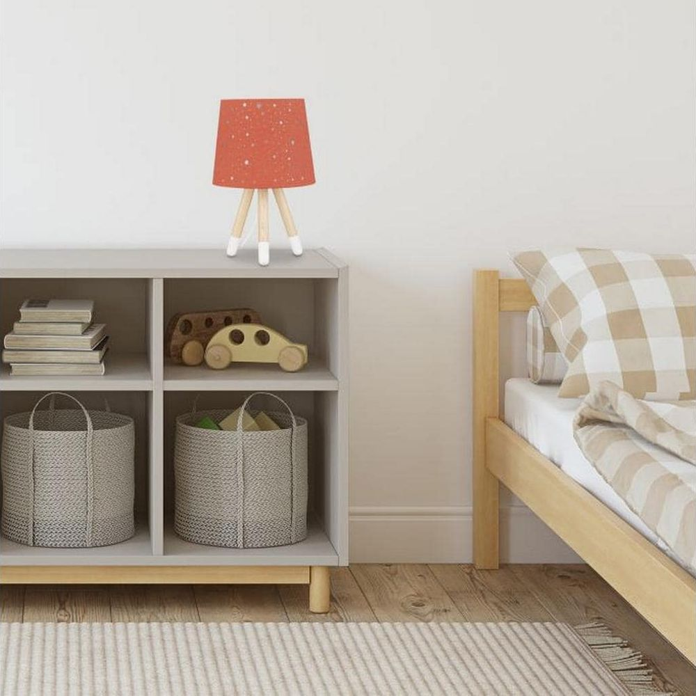 Kinderzimmer mit Regal, Spielzeugauto, Lampe und Bett mit karierter Bettwäsche.