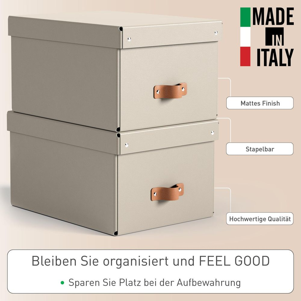 Zwei beige Aufbewahrungsboxen mit Ledergriffen, gestapelt. Mit "Made in Italy" Aufkleber.