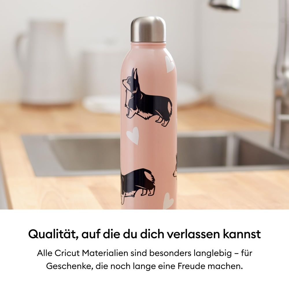 Rosa Wasserflasche mit schwarzen Corgis und weißen Herzen. Auf einer Küchenzeile.