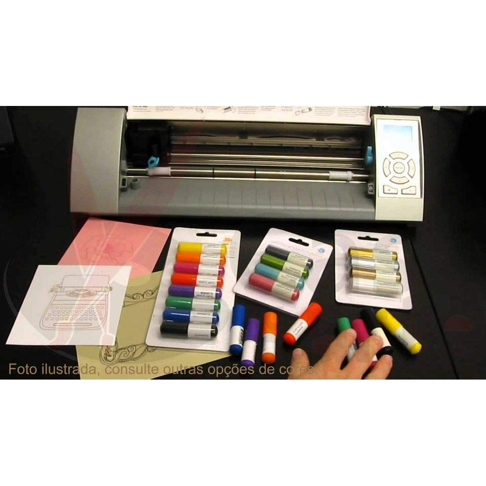 Eine Schneidemaschine mit bunten Marker-Stiften und Papierdesigns auf einem Tisch.