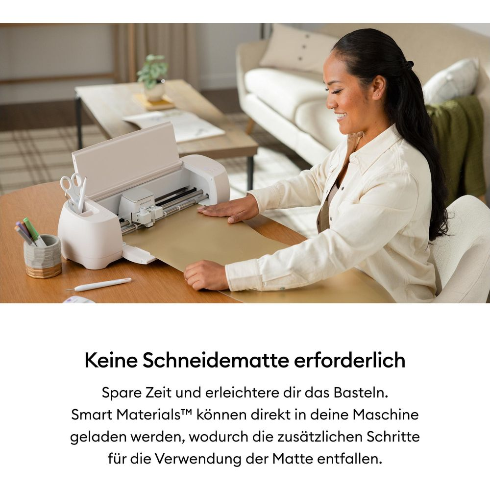 Eine Frau lächelt, während sie ein Schneidegerät mit einem großen, goldenen Blatt Material bedient.