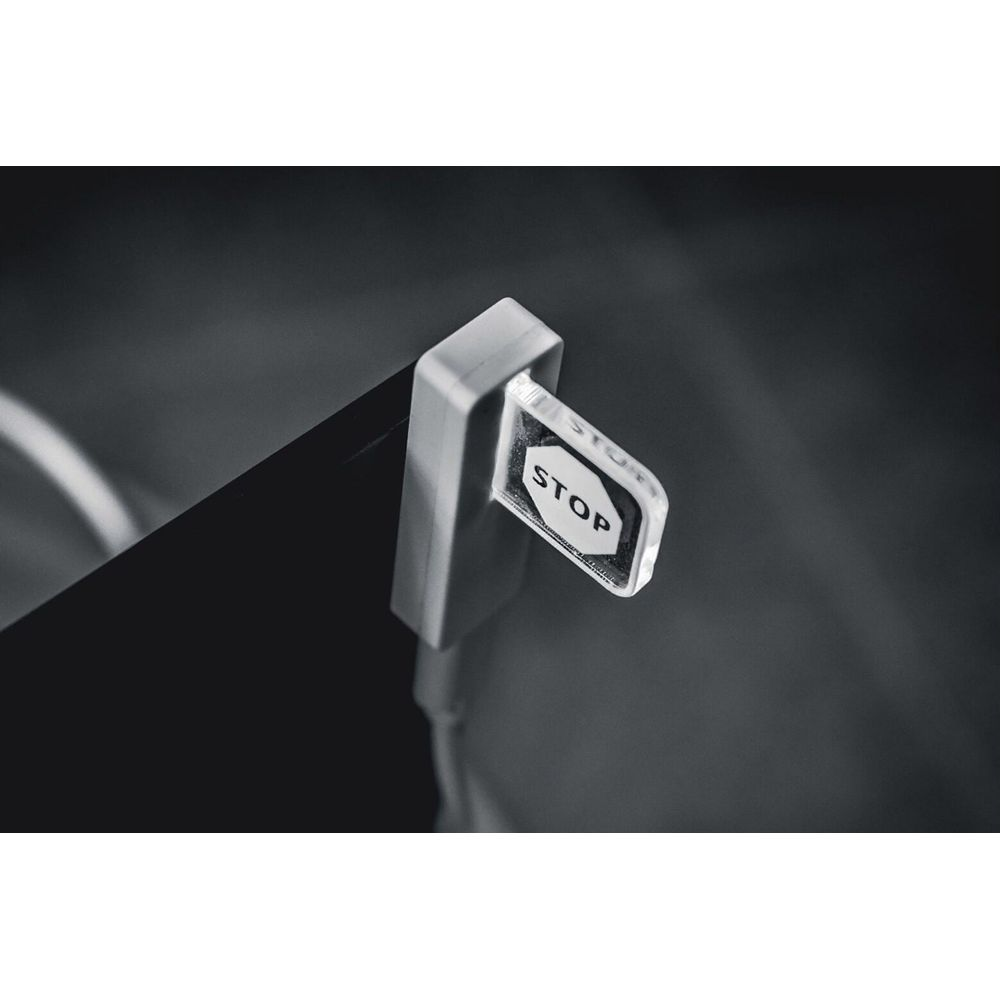 Un interrupteur blanc "STOP" sur fond noir, au point focal.