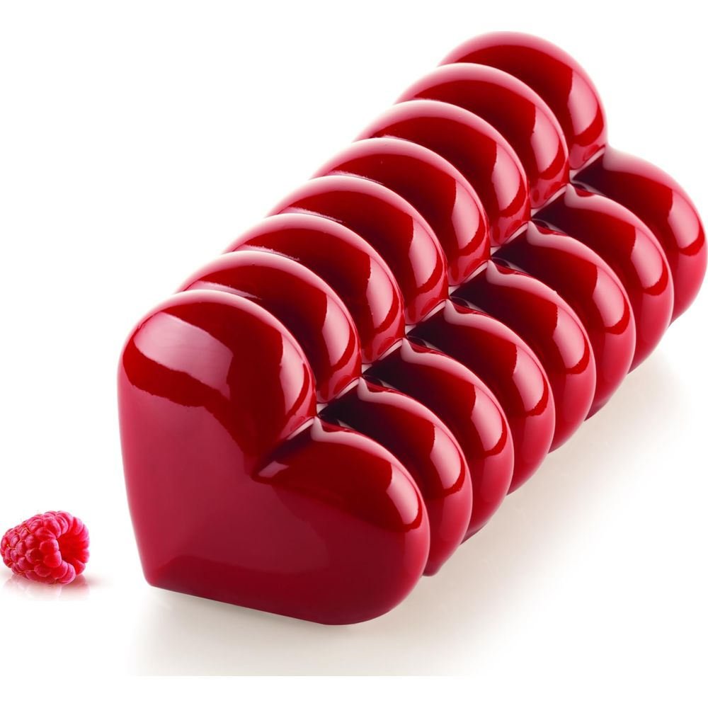 Rote Herzform-Kuchen mit einem Himbeerelement daneben.