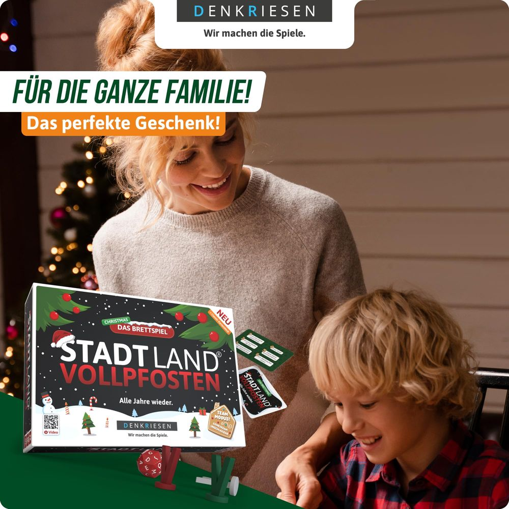 Mutter und Sohn halten ein Brettspiel mit Weihnachtsmotiv. Sie lächeln.