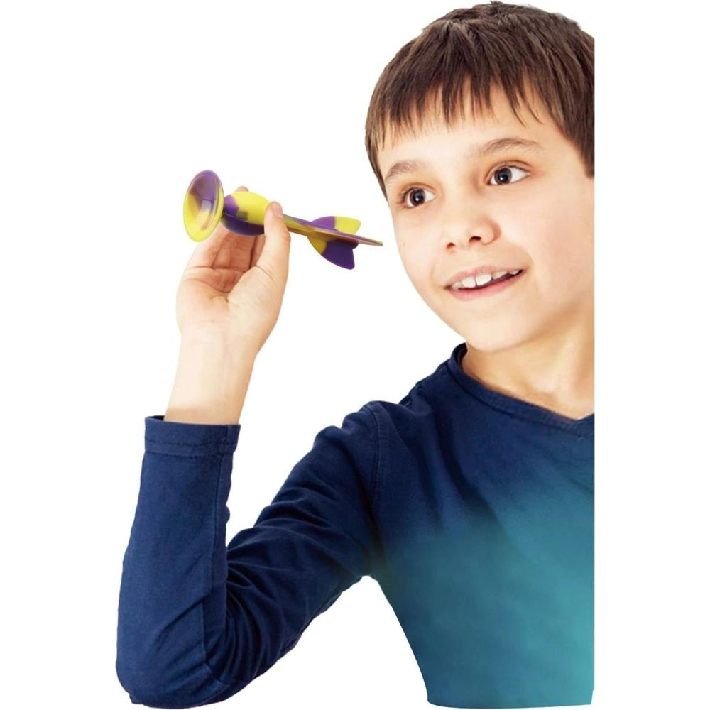 Ragazzo tiene un aeroplano giocattolo giallo e viola con ventosa.