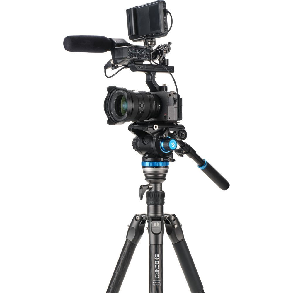 Una videocamera professionale su treppiede, dotata di microfono e monitor.