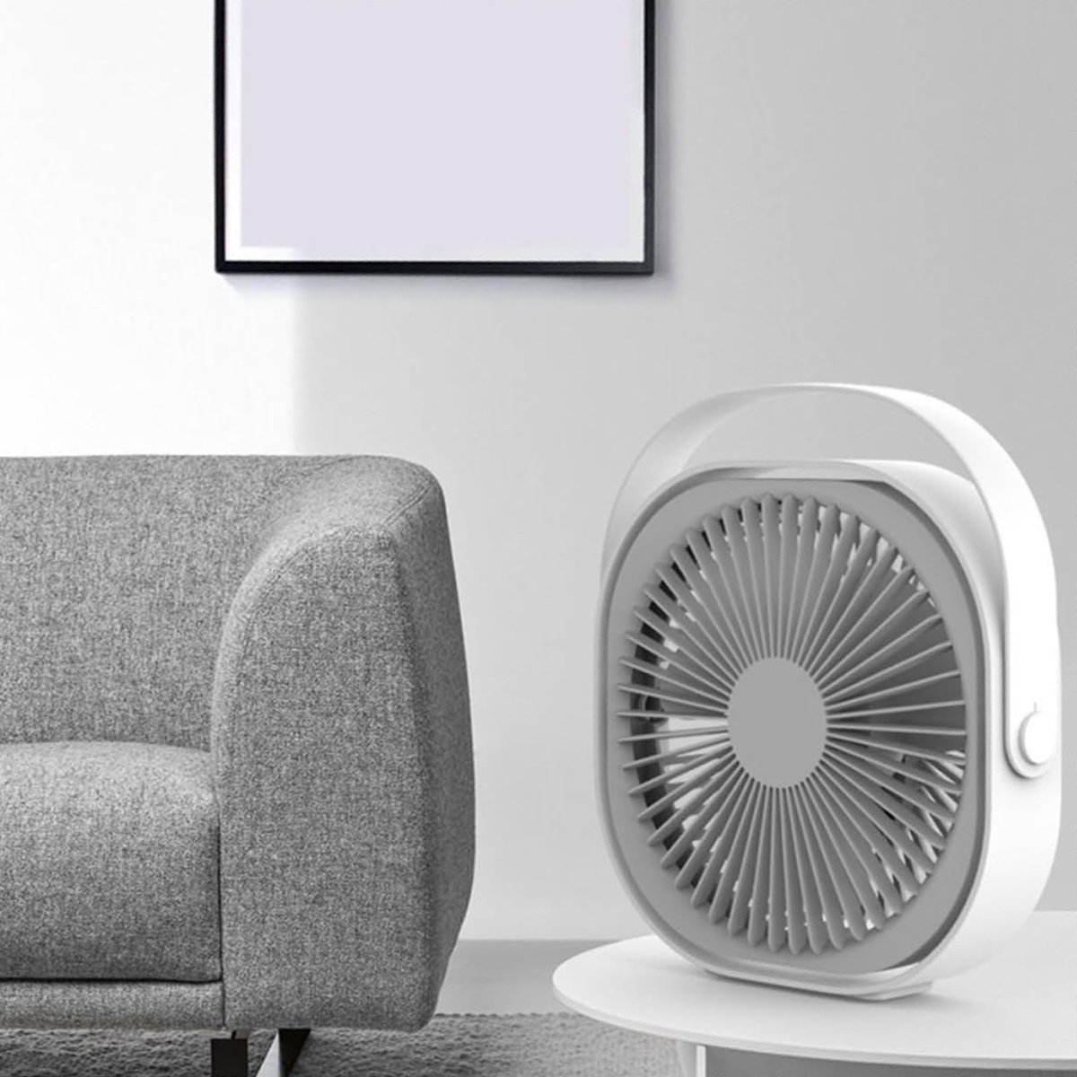 Ein weißer Ventilator steht auf einem Tisch neben einem grauen Sofa.