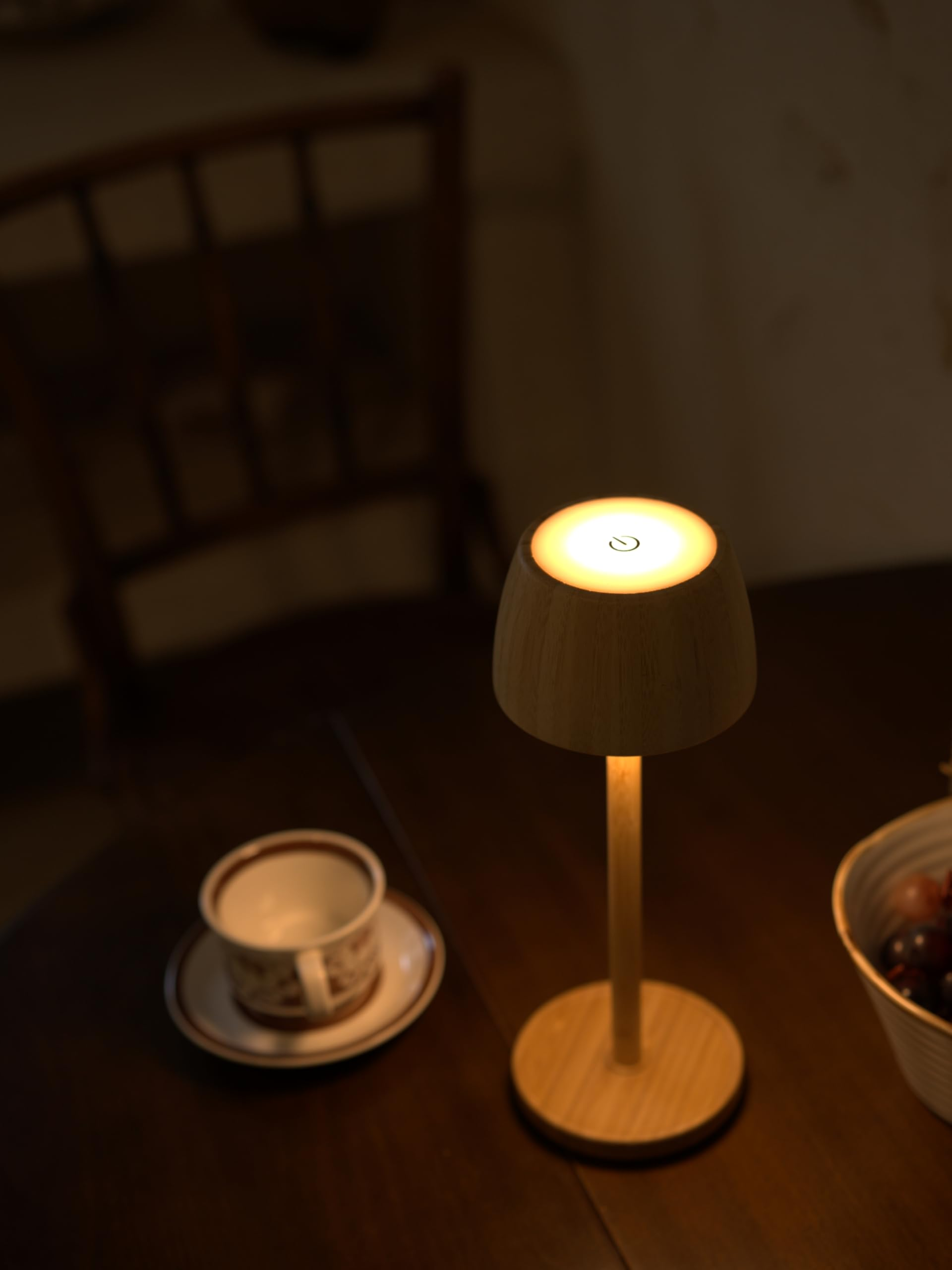 Ein Nachttisch mit einer Lampe, einer Tasse und Obst.