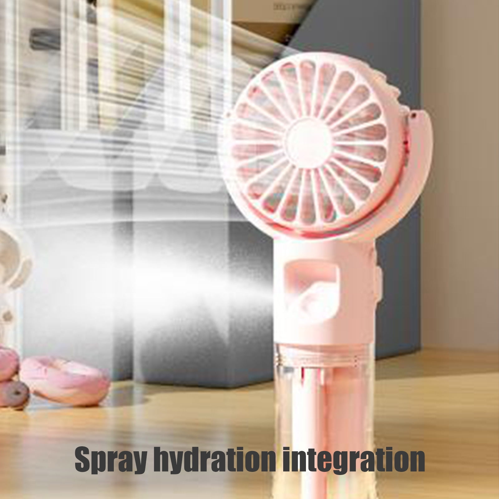 Ein rosa Handventilator mit Sprühfunktion steht auf einem Holztisch neben rosa Gegenständen.