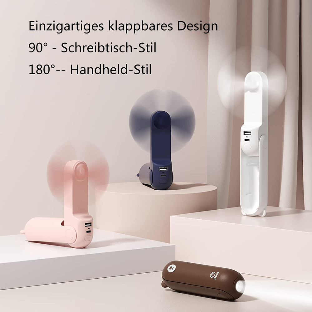 Drei faltbare Lüfter in Rosa, Blau und Weiß, eine braune Lampe.