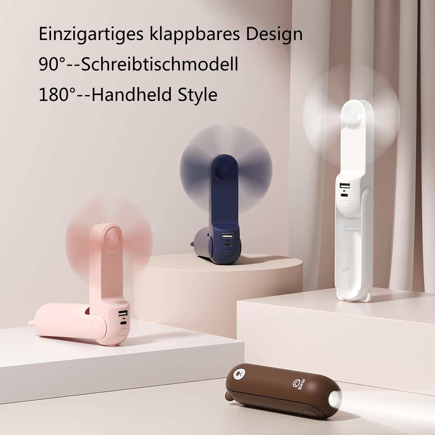 Drei faltbare Ventilatoren in Rosa, Blau und Weiß, ein brauner Bär mit Licht.