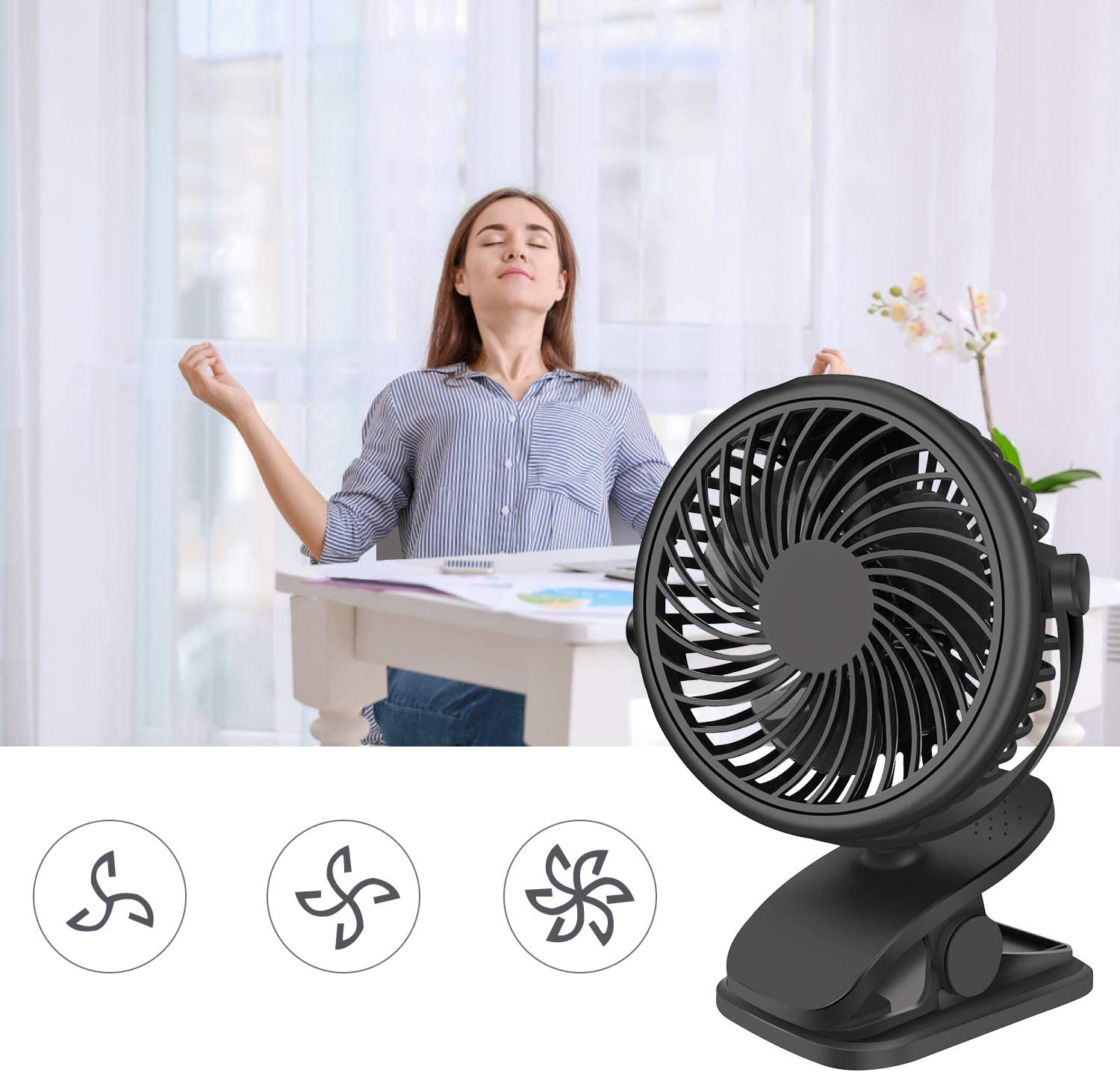 Ein schwarzer Clip-Ventilator steht auf einem Schreibtisch neben einer Frau.