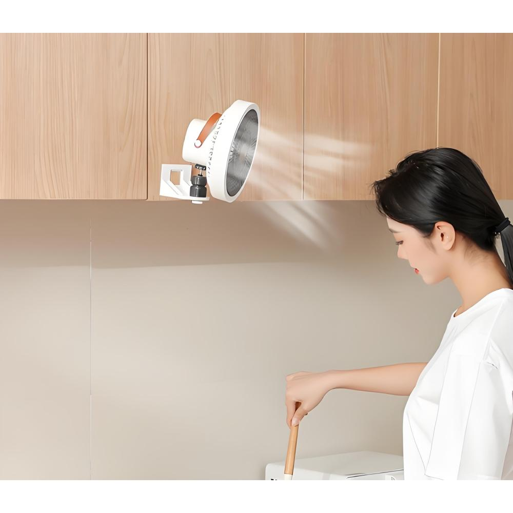 Eine Frau kocht, während ein Ventilator über ihr hängt.