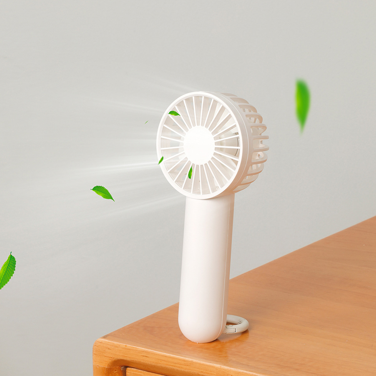 Ein kleiner weißer Ventilator mit Blättern, die durch die Luft fliegen.