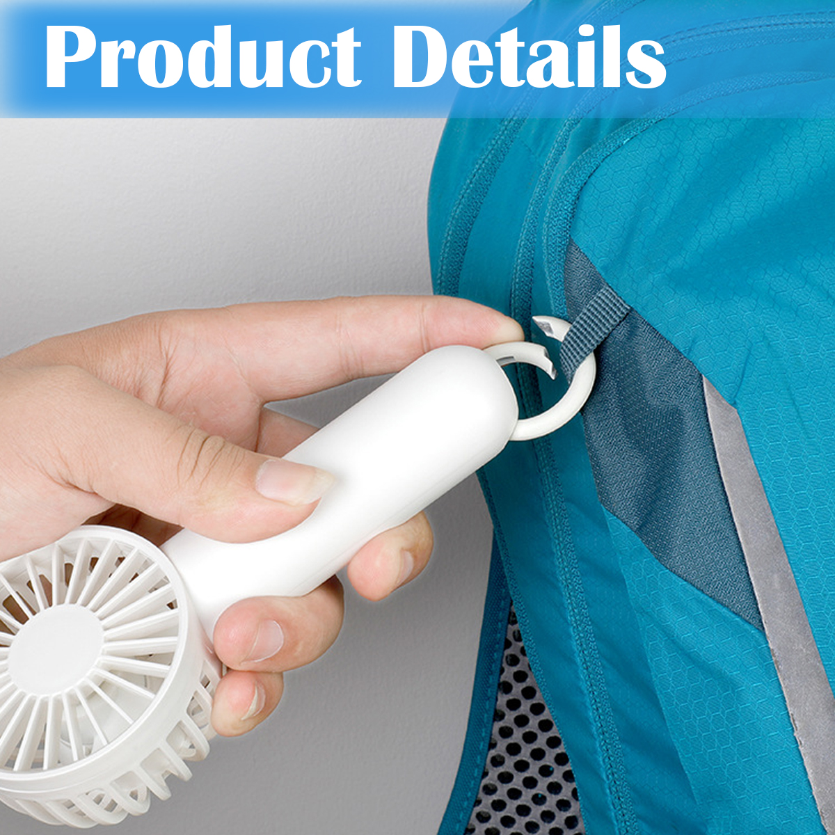 Hand hält weißen Mini-Ventilator, der an einer blauen Tasche befestigt wird.
