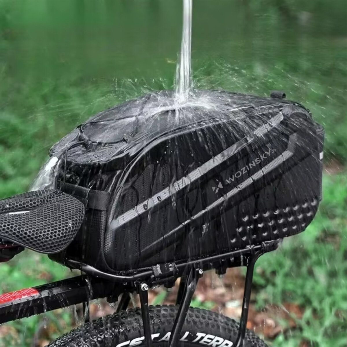 Eine schwarze Wozinsky-Fahrradtasche wird mit Wasser besprüht, was ihre Wasserbeständigkeit zeigt.