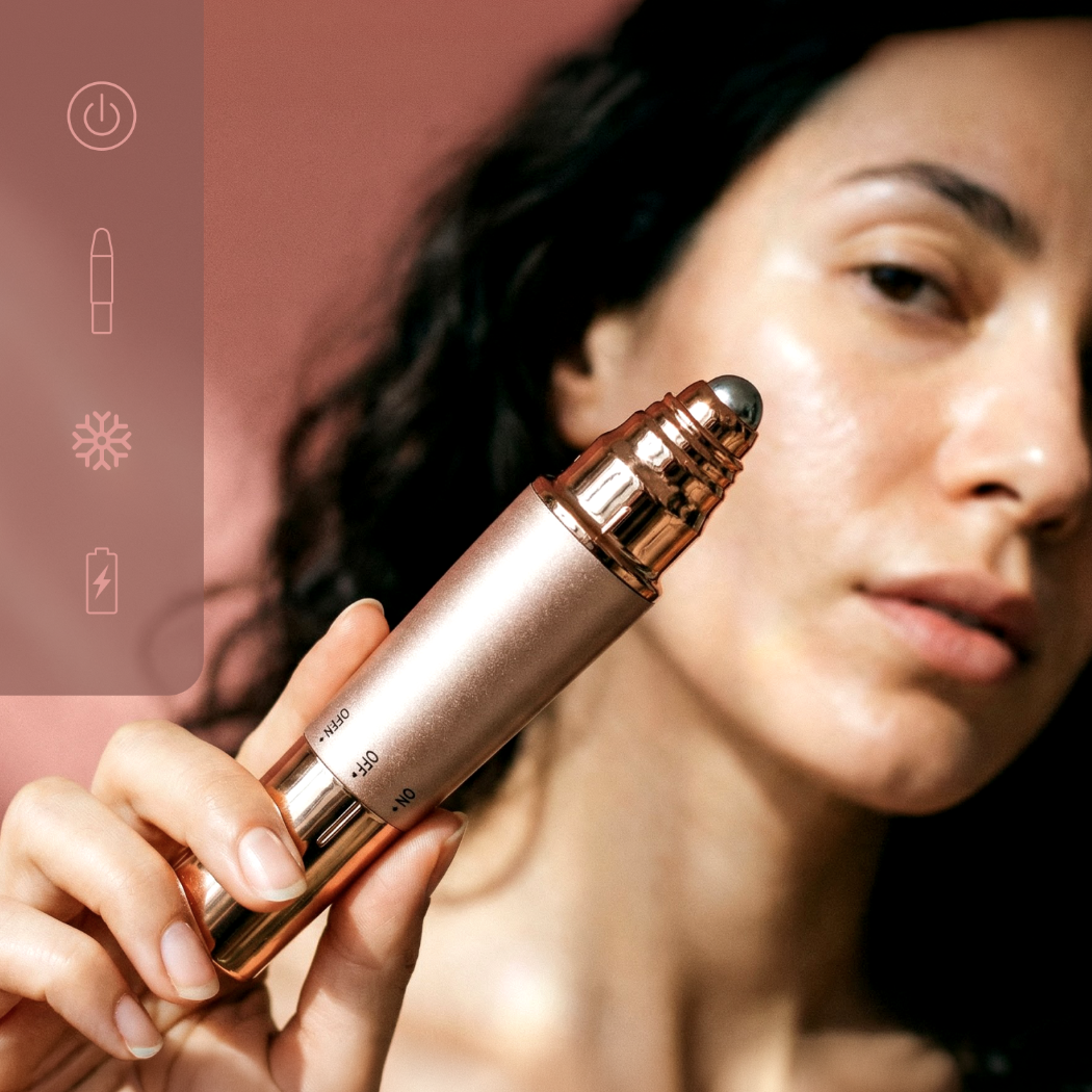 Kobieta trzyma różowo-złote urządzenie do pielęgnacji skóry z metalową kulką.