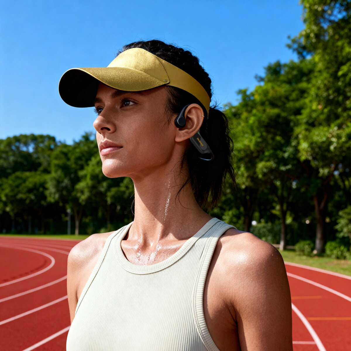 Una donna con visiera dorata e cuffie sta su una pista da corsa.