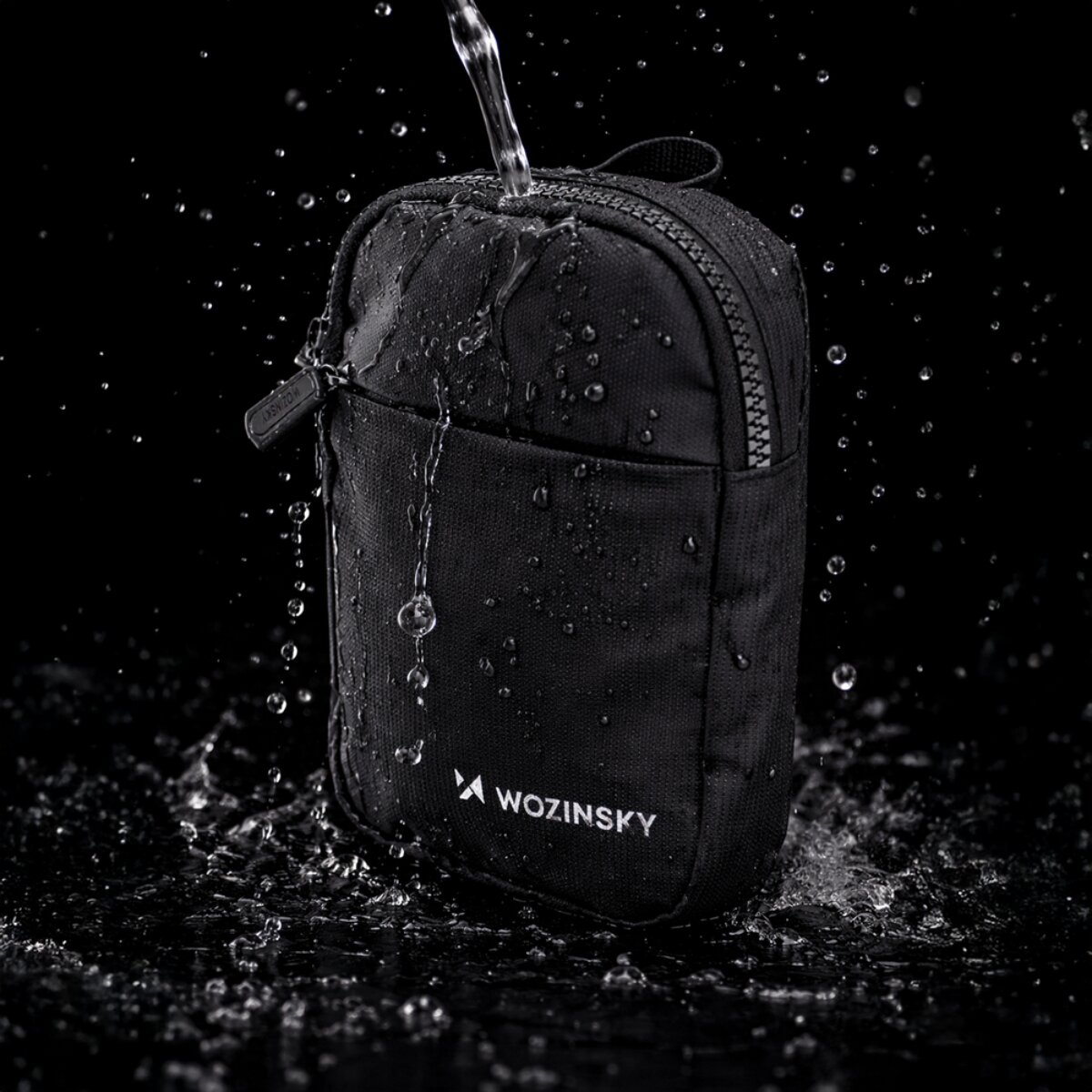 Borsa nera con acqua che cola e schizzi in studio.