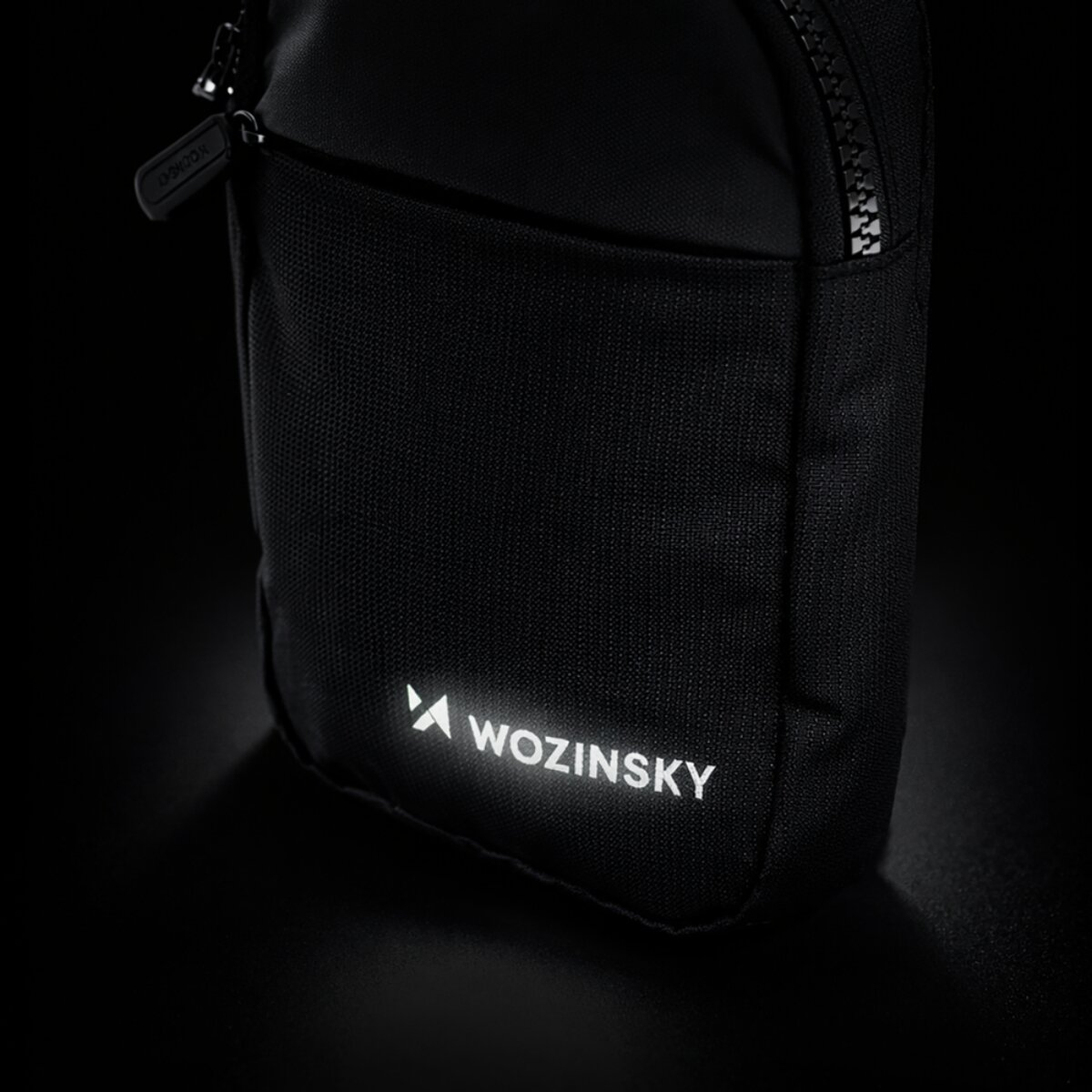 Borsa nera con cerniera e logo riflettente.
