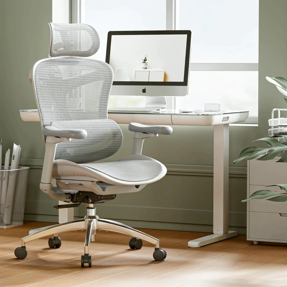 Chaise de bureau ergonomique gris clair et bureau avec ordinateur.