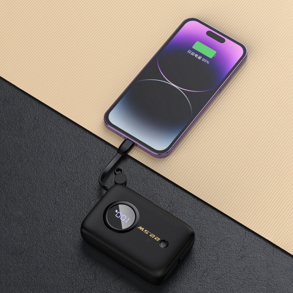 Ein schwarzer Powerbank lädt ein violettes Smartphone auf einem zweifarbigen Hintergrund.