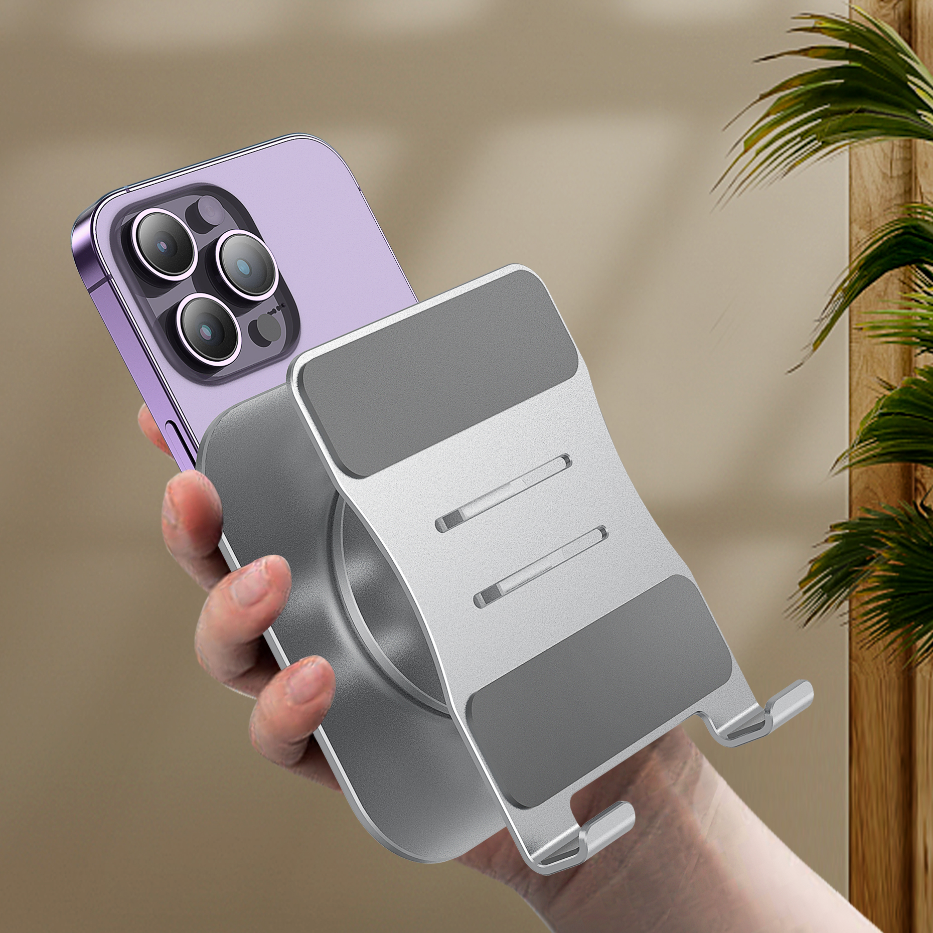 Eine Hand hält ein lila Smartphone auf einem silbernen Ständer.