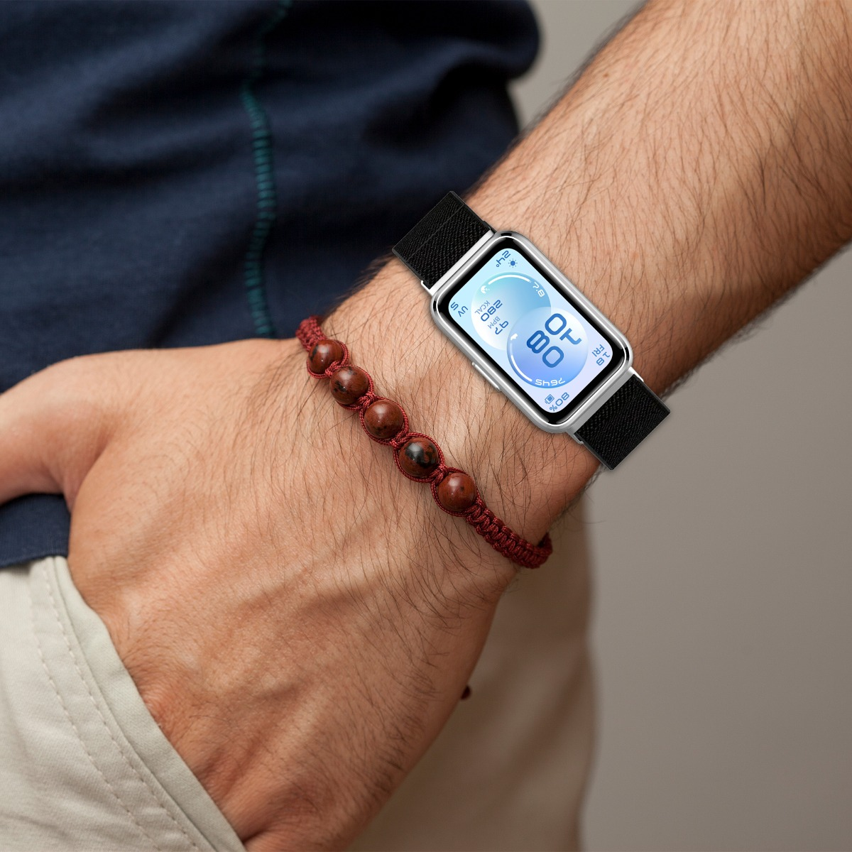 Nahaufnahme eines Handgelenks mit einer Smartwatch und einem Perlenarmband.