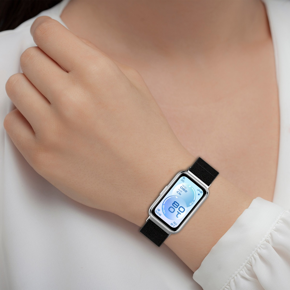 Eine silberne Smartwatch mit schwarzem Band an einem Handgelenk.