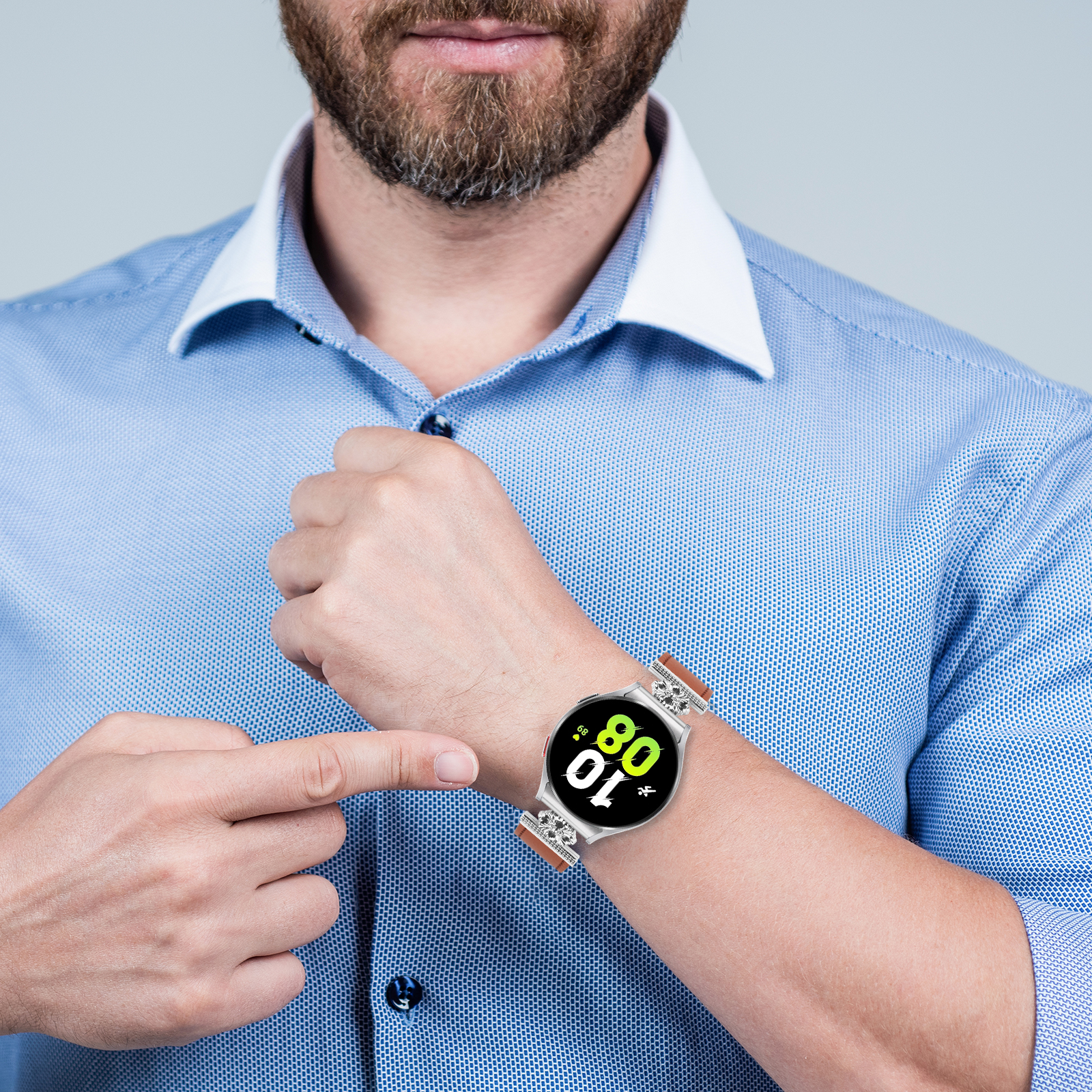 Mann in blauem Hemd zeigt auf seine Smartwatch mit braunem Armband.